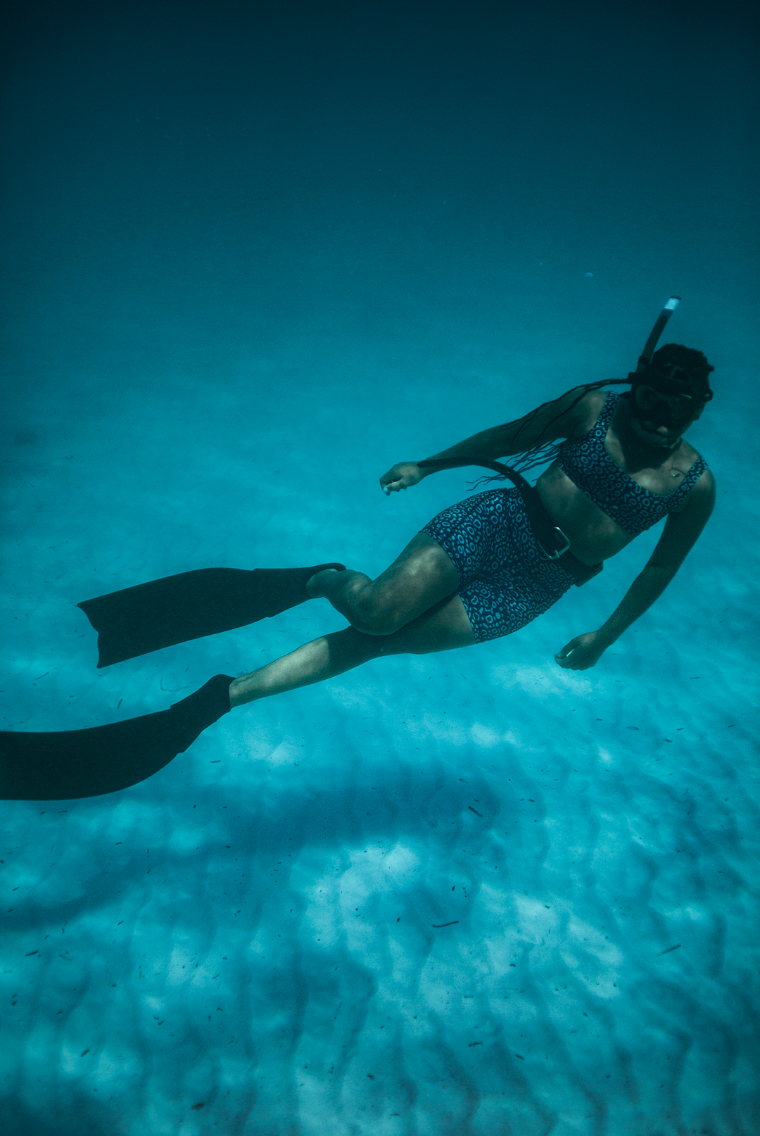 Close-up of high waist workout shorts with Eagle Ray print in shades of blue, eco-friendly active swimwear, women’s side pocket biker shorts, sustainable swimwear UK.