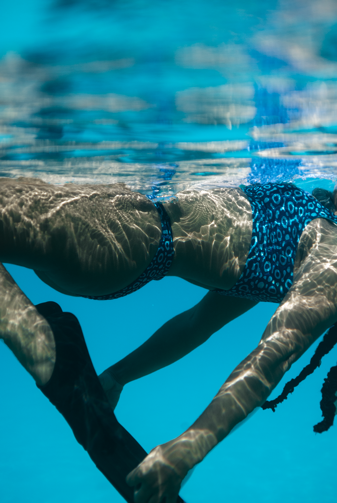 Women’s Eagle Ray print bikini bottoms in two-tone blue marine animal print, high leg style, eco-friendly apparel active swimwear made from recycled ghost nets.