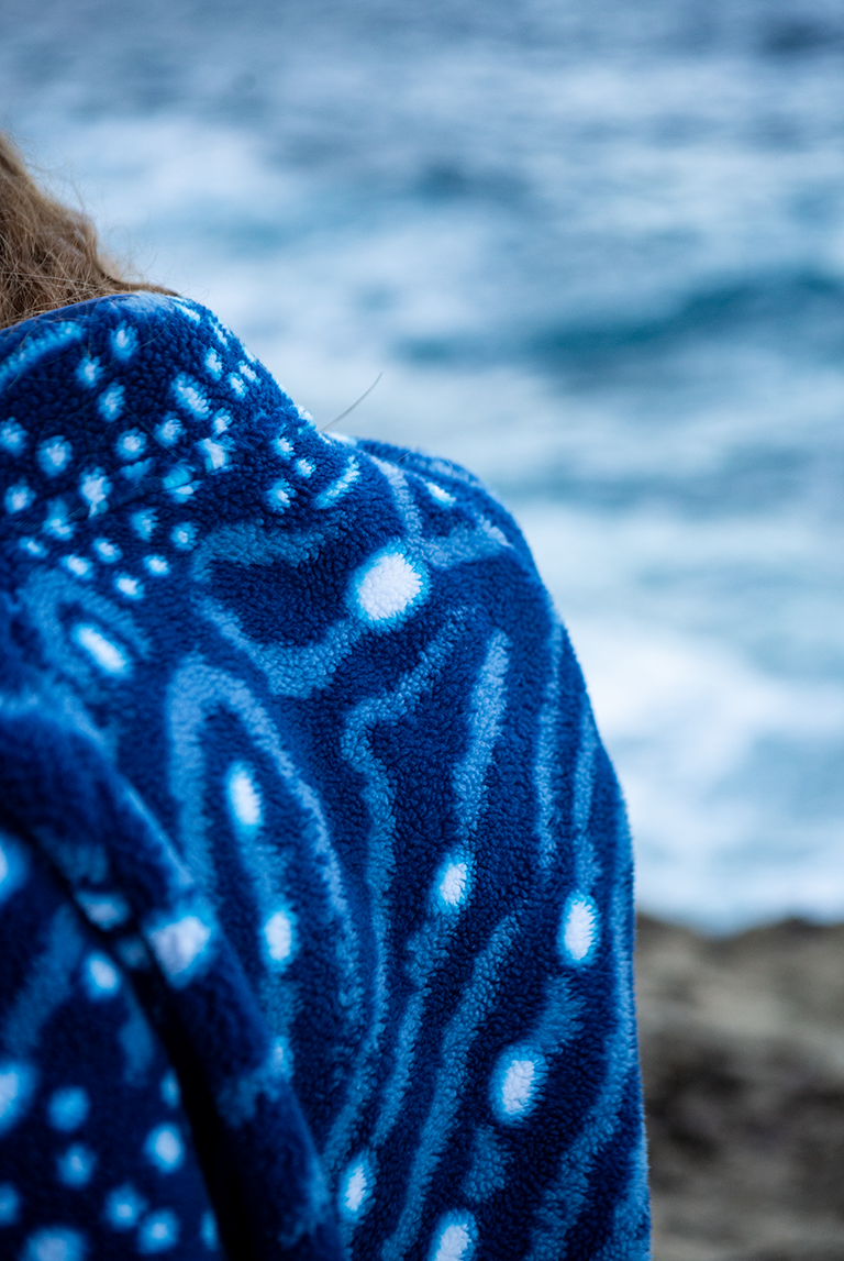 Close-up of the soft recycled fleece fabric showing whale shark spot pattern and sherpa texture.