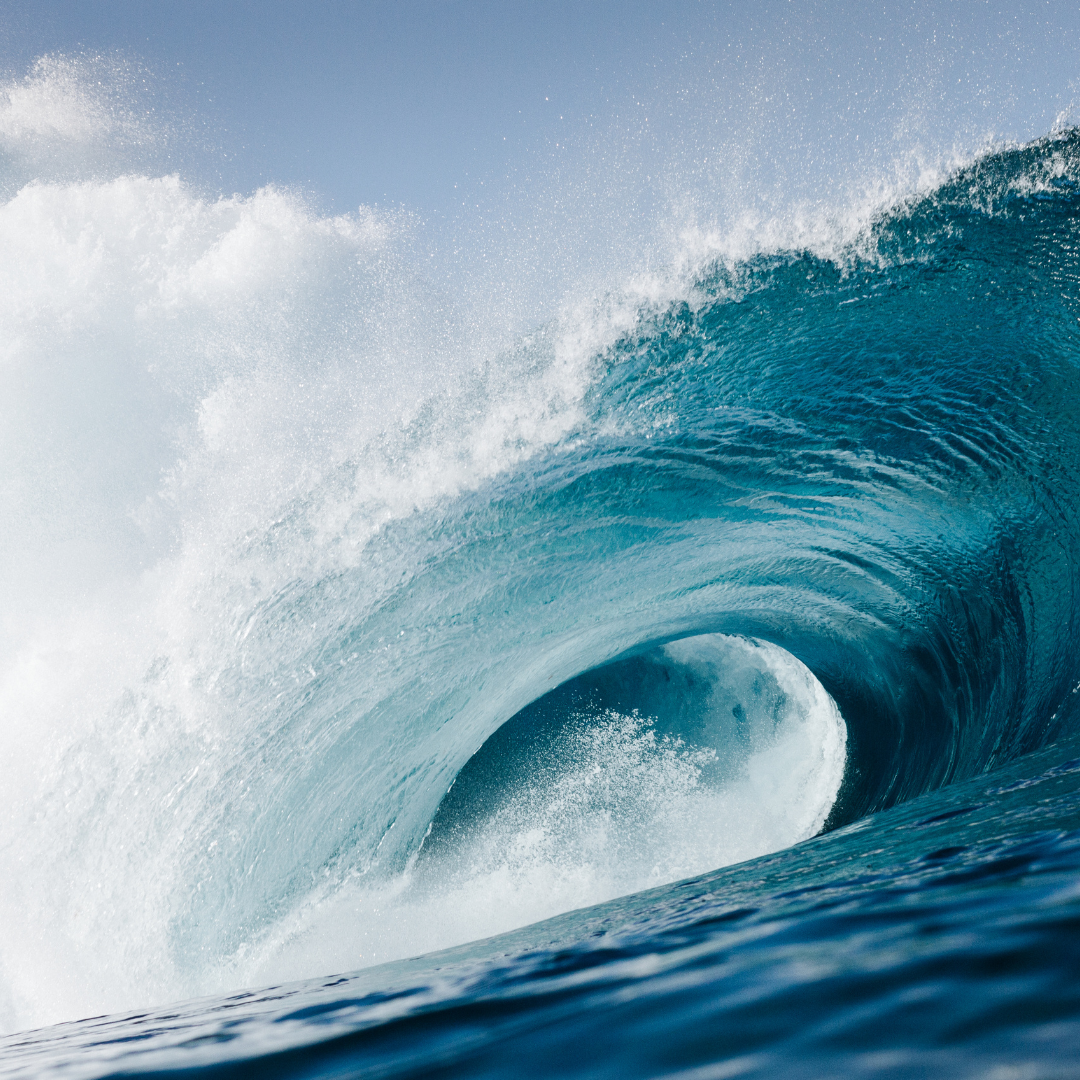Powerful wave curling over itself with a clear sky background