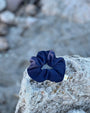 Bluefin navy blue scrunchie on a textured rock surface with a blurred natural background
