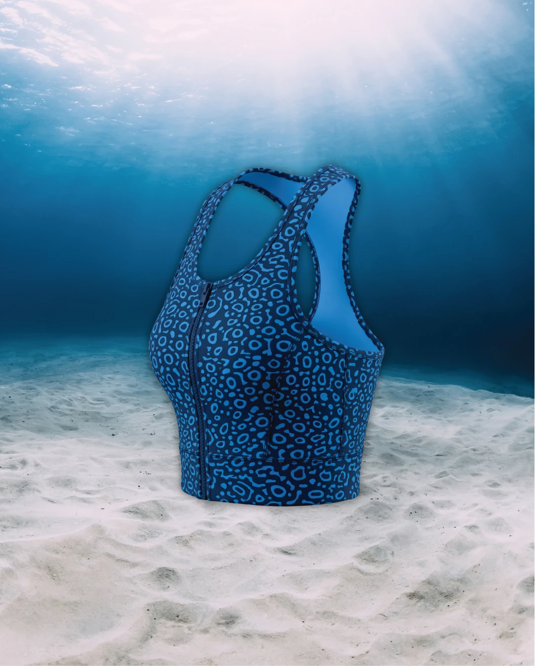 Eagle Ray Racer Back Zip Sports Bra Bikini Top side view on ghost mannequin, made from recycled fishing nets and designed for movement in and around the water.