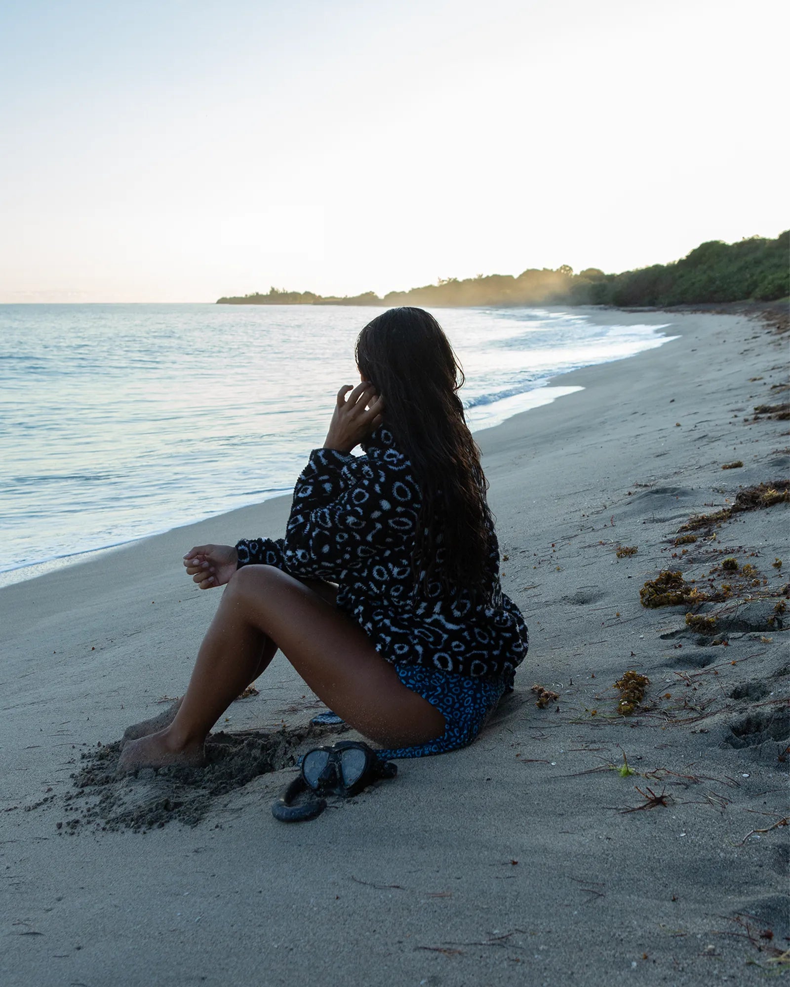 Model wearing the NAUTRA Eagle Ray Recycled Sherpa Half Zip Fleece on a coastal beach.