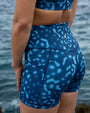 Close-up of NAUTRA Whale Shark high-waisted recycled biker shorts showing seam detail and ocean-inspired print.