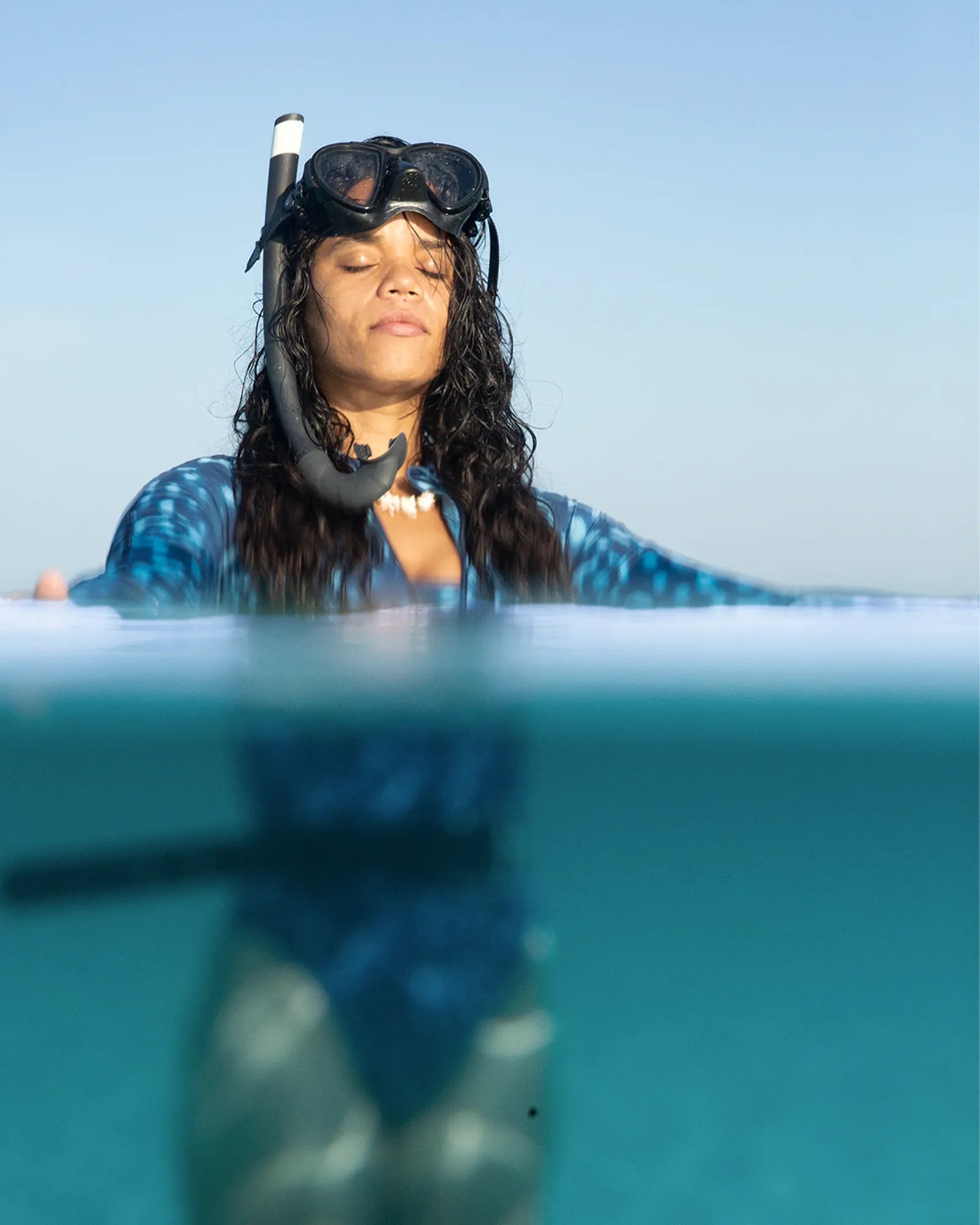 NAUTRA Whale Shark long-sleeve one-piece swimsuit worn while snorkelling, sustainable surf swimsuit inspired by the whale shark.